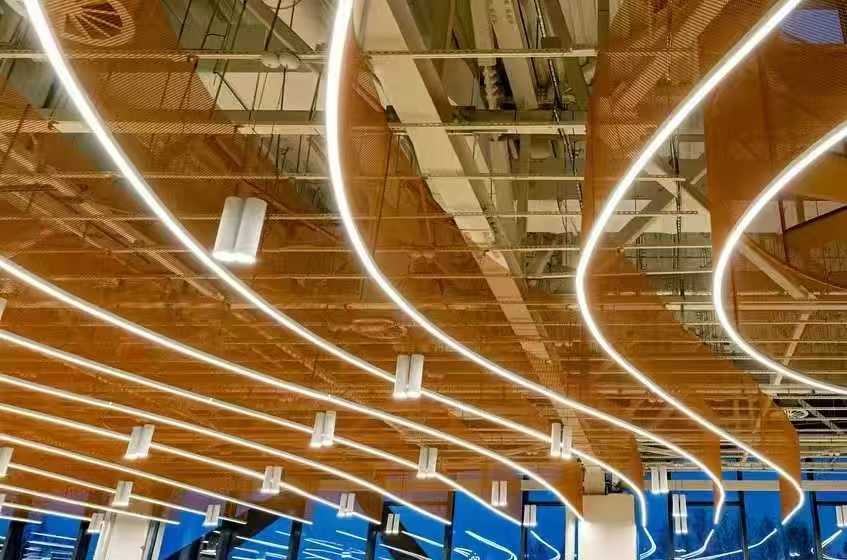 Close-up of curved LED linear lights in airport ceiling